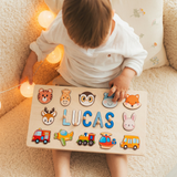 Toddler playing with a personalised wooden name puzzle spelling Lucas with animal and vehicle pieces